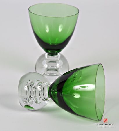 null Two glass liqueur glasses, the green tinted goblet of conical form rests on...