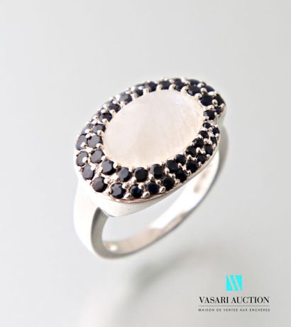 null Silver ring centered on a cabochon moonstone hemmed with double lines of sapphires.
Gross...