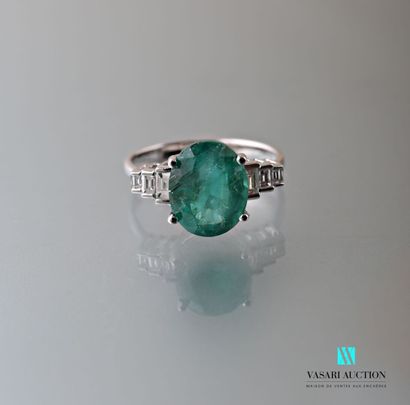 null Ring in white gold 750 thousandth set in its center with an oval emerald calibrating...
