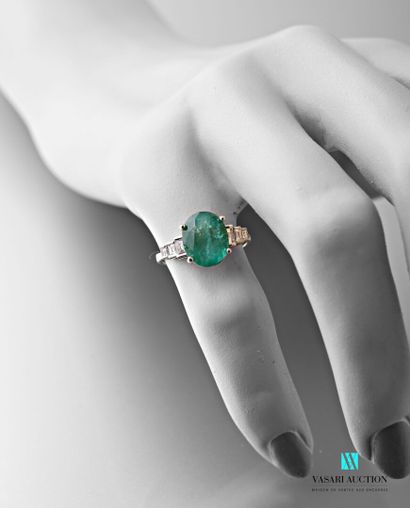 null Ring in white gold 750 thousandth set in its center with an oval emerald calibrating...