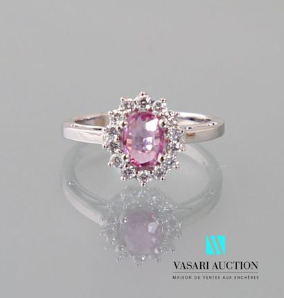 null Ring in 750 thousandths white gold set in its center with an oval-cut pink sapphire...