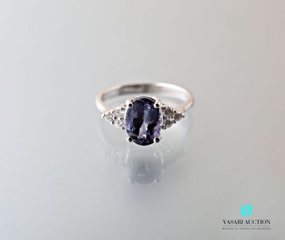 null 750 thousandths white gold ring set in its center with an oval-cut Tanzanite...