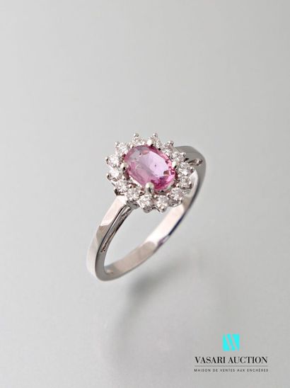 null Ring in 750 thousandths white gold set in its center with an oval-cut pink sapphire...