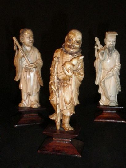 null Trois figurines en ivoire reposant sur un socle en bois figurant des Sages chinois.

Haut....