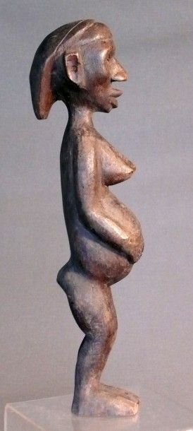 null Statuette en bois à patine sombre figurant une femme enceinte debout, le visage...