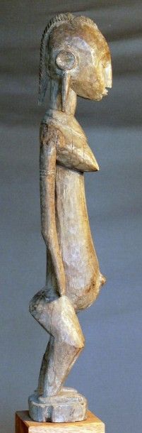 null Statuette «Jonyeleni » en bois dur à patine naturelle figurant une femme debout,...