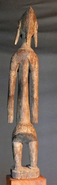 null Statuette «Jonyeleni » en bois dur à patine naturelle figurant une femme debout,...