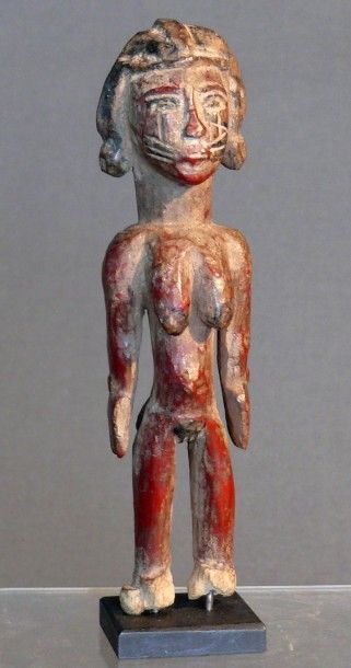 null Statuette féminine en bois dur à traces de teinture rouge figurant une femme...