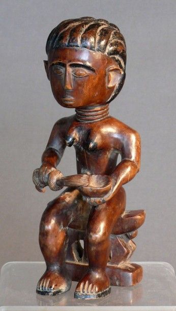 null Statuette féminine en bois dur patiné finement sculptée figurant une femme assise...
