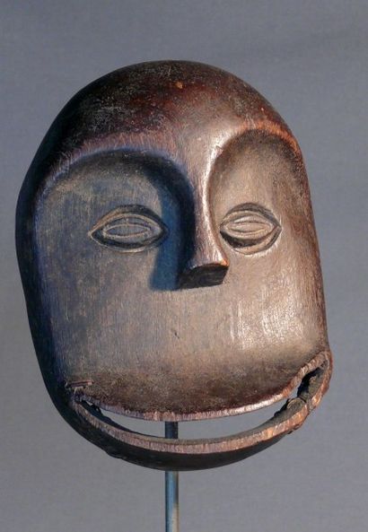 null Masque facial « Sokomotu » en bois dur à patine sombre d’usage figurant un visage...