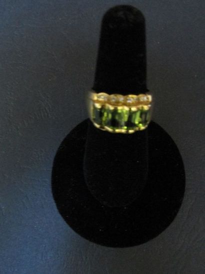 null Bague en or jaune, ornée d’un motif

ondulant, sertie de péridots, entre deux...