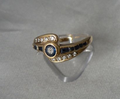 null Bague en or jaune, sertie d'un saphir rond, encadré d'une ligne de saphirs calibrés...