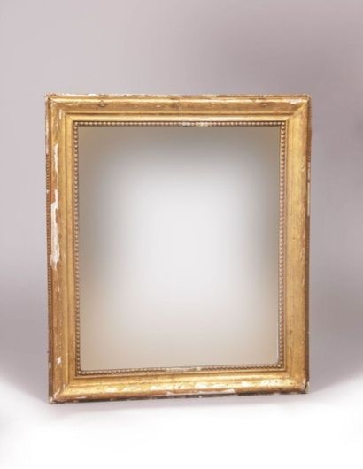 null Miroir de forme rectangulaire en bois et

stuc doré à décor d’une frise de perles...