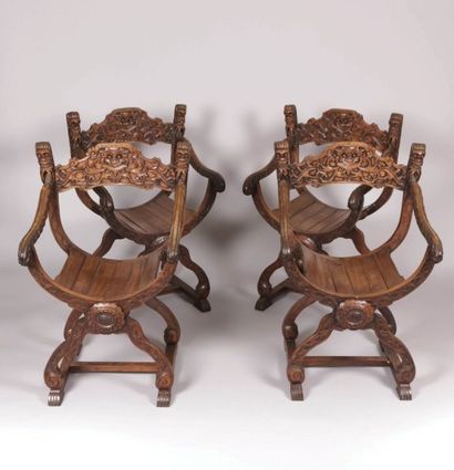 null Suite de quatre fauteuils curules en
bois naturel sculpté à décor sur le bandeau
d'une...