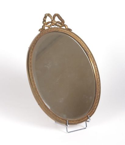 null Miroir de forme ovale en métal doré à décor à l'amortissement d'un noeud de...