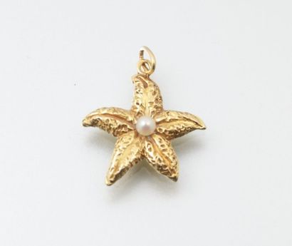 null Pendentif en or jaune figurant une étoile de mer ornée en son centre d'une perle...