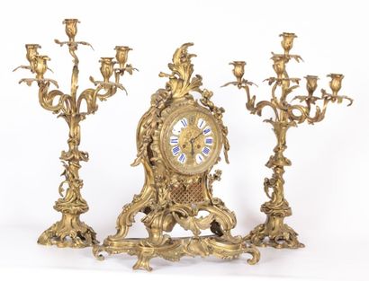 null Garniture de cheminée en bronze

composée d'une pendule et de deux flambeaux

à...