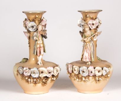 null Paire de vases en porcelaine poychrome à décor en ronde-bosse d'un jeune homme...