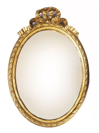 null Miroir en bois doré et sculpté à vue ovale, le fronton à décor d'un noeud de...