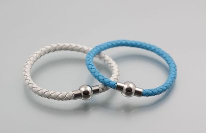 null Deux bracelets de cuir tressé, l'un bleu, l'autre blanc. Fermoir rond aiman...