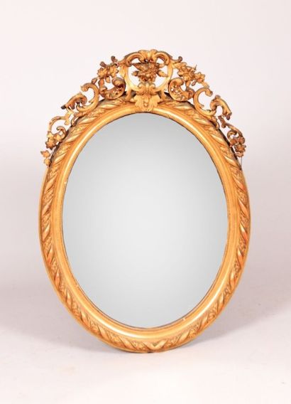 null Miroir en bois et stuc mouluré, sculpté et doré de forme médaillon, le bandeau...