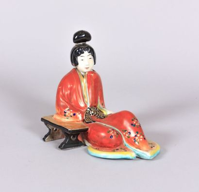 null Sujet en porcelaine polychrome figurant une geisha en kimono accoudée sur un...