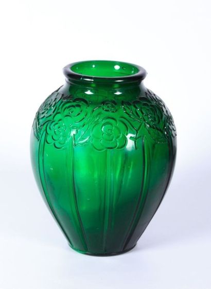 null Vase en verre vert moulé de forme ovoïde, l'épaule ornée de fleurs, la panse...