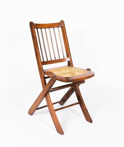 null Chaise pliante en bois naturel vernis, le dossier à barreaux et l'assise cannée
XXème...
