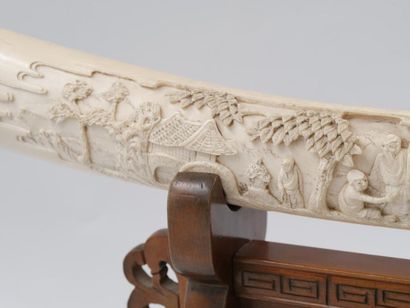 null JAPAN 
Elephant tusk with carved decoration of conversing figures in a landscape...