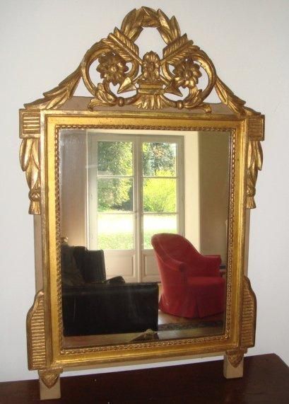 null Miroir en bois sculpté et doré à fronton ajouré, décor aux flèches. XVIIIème...