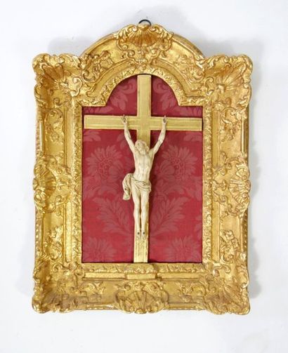 null Christ on a cross in ivory, the frame in carved and gilded wood with shell decoration.

Regency...