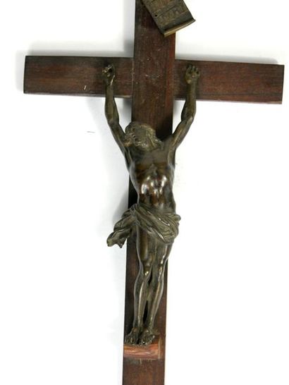 null Crucifix composed of a bronze Christ with a brown patina, the head tilted to...