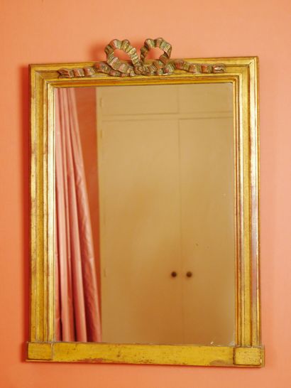 null 
Miroir en bois mouluré et doré de forme rectangulaire surmonté d'un noeud....