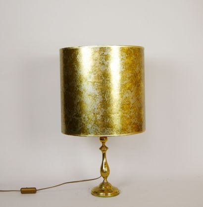 null 
Lampe en métal doré de forme balustre à décor ciselé représentant des végétaux....