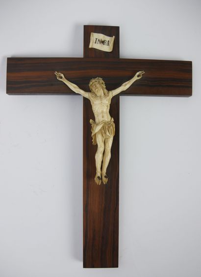 null Christ en os sculpté, présenté sur une croix en bois et surmonté d'une plaquette...