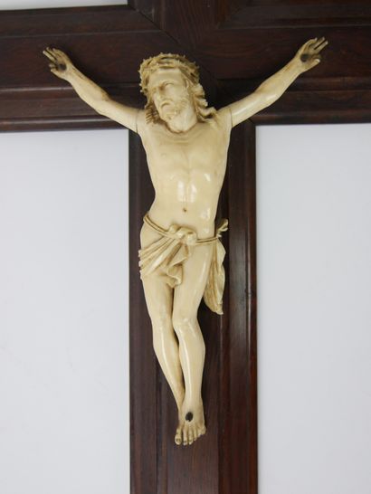 null Christ en os sculpté, présenté sur une croix en bois et surmonté d'une plaquette...