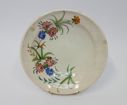 null Round earthenware dish decorated with flowers on a beige background. Alsatian...