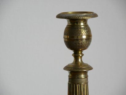 null A pair of gilt brass torches with a baluster shaft resting on a circular base....