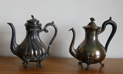 null Two silver plated metal and blackened wood teapots. The first one resting on...