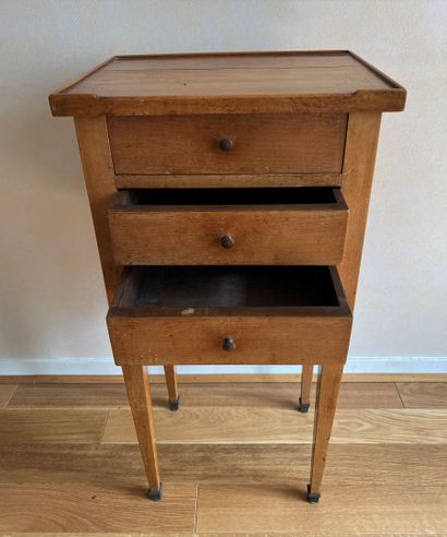 null Bedside table in fruitwood opening to three drawers resting on sheath feet finished...