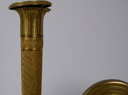 null A pair of chased and gilt bronze candlesticks decorated with acanthus leaves...