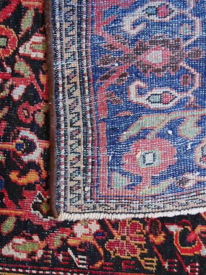 null Tapis en soie à une large bordure à décor de rinceaux sur fond bleu, le centre...