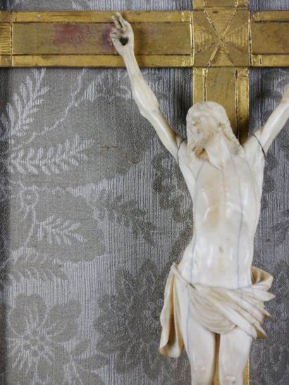 null Crucifix en ivoire, dans un encadrement en bois sculpté et redoré à fronton...