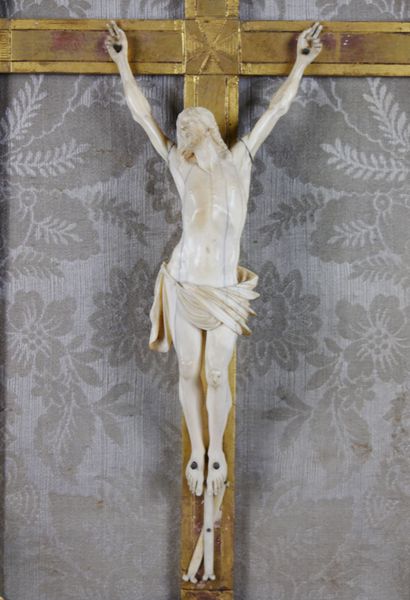 null Crucifix en ivoire, dans un encadrement en bois sculpté et redoré à fronton...