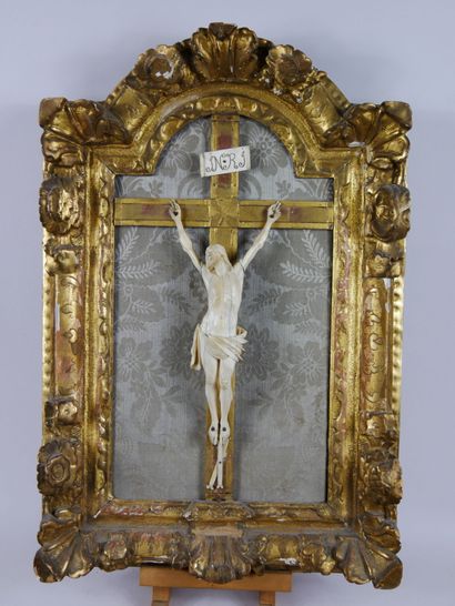 null Crucifix en ivoire, dans un encadrement en bois sculpté et redoré à fronton...