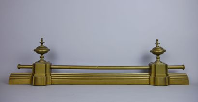 Barre de foyer en métal doré à décor de toupies....