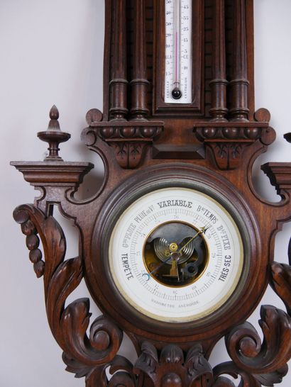 null Aneroid barometer with centigrade thermometer on a carved wooden stand decorated...