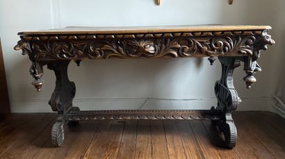 null Rectangular shaped table in natural wood richly carved with scrolls and heads...