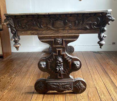 null Rectangular shaped table in natural wood richly carved with scrolls and heads...