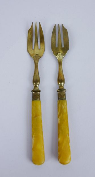 null Suite of 12 cake forks in gilded metal and yellow tinted resin. Length : 16,5...
